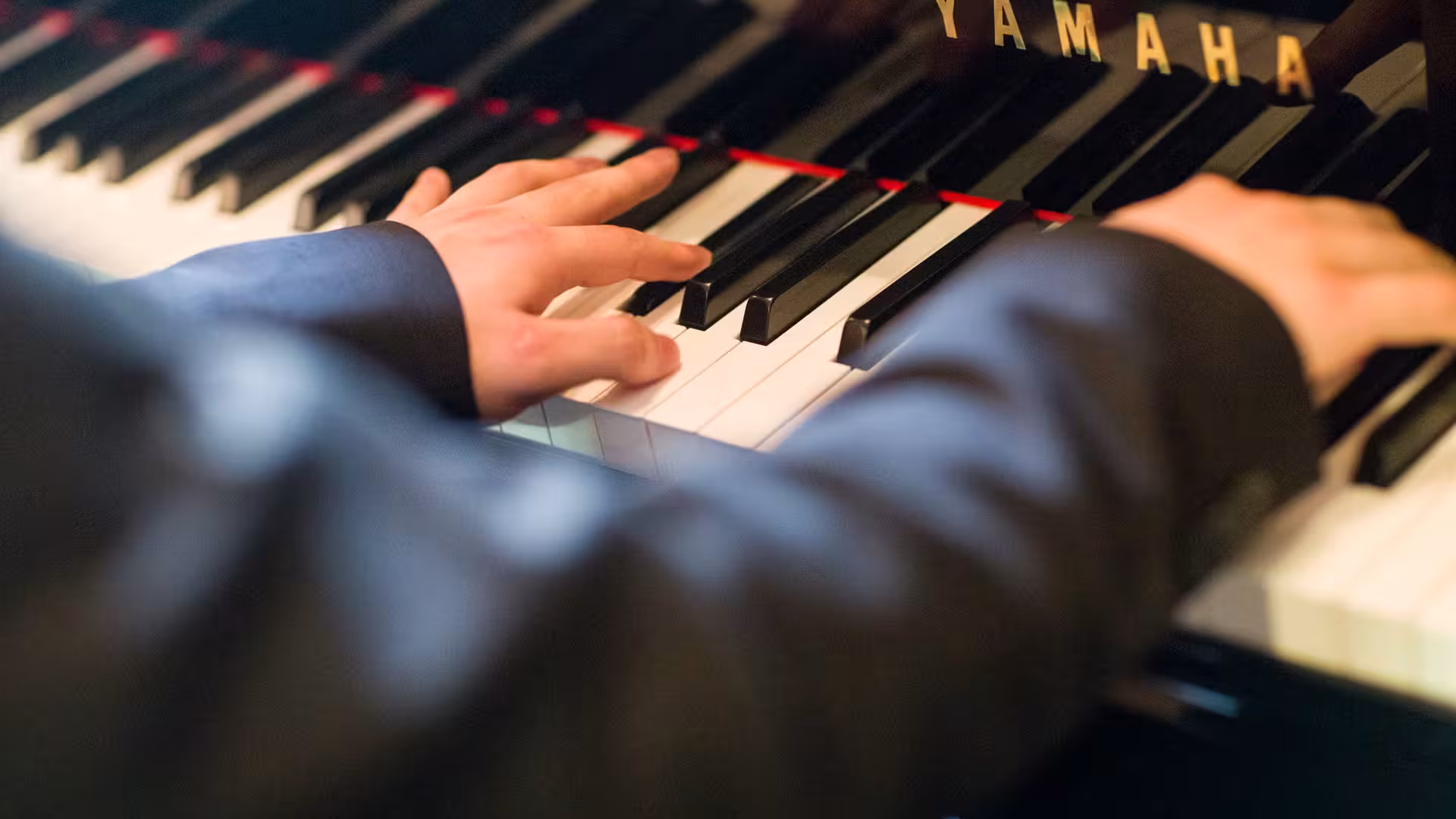 Hands playing piano keyboard